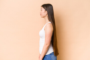 Young Chinese woman isolated on beige background