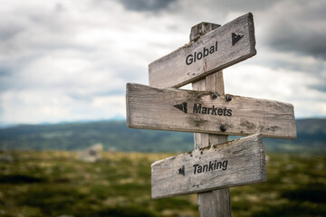 global markets tanking text quote on wooden signpost outdoors in nature. Inflation, economy and markets concept.