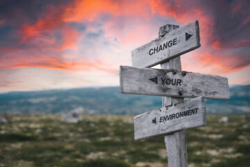 change your environment text quote on wooden signpost outdoors in nature. yourself, new start and life concept