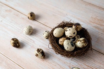 Easter banner with quail eggs in the nest on wooden table. Rustic.