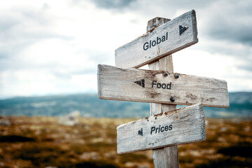 global food prices text quote on wooden signpost outdoors in nature. Inflation, economy and finance...