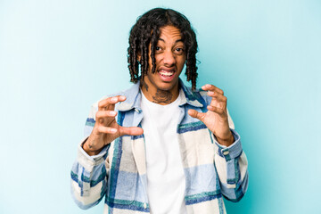 Young African American man isolated on blue background screaming with rage.