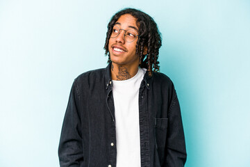 Young African American man isolated on blue background relaxed and happy laughing, neck stretched showing teeth.
