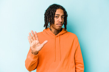 Young African American man isolated on blue background rejecting someone showing a gesture of...