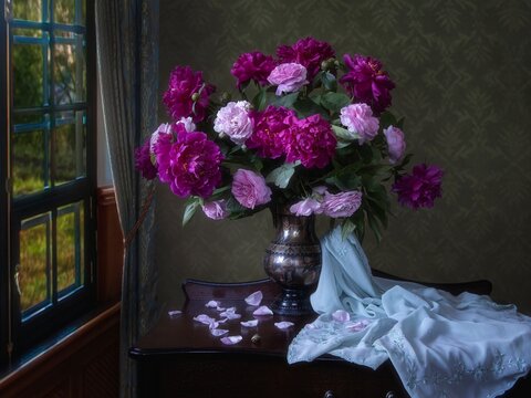 Still life with bouquet of roses and peonies in the interior