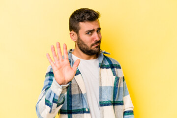 Young caucasian man isolated on yellow background rejecting someone showing a gesture of disgust.