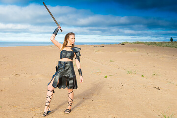 medieval brigand cosplayer wearing leather lorica, skirt, bracer and brassart with two-handed...