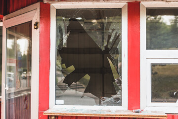 Broken window of a shop or home. Shattered glass of a construction - 510662814