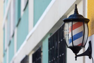 Small barber pole installed on the entrance wall to a barbershop