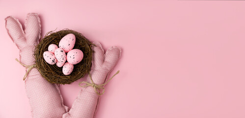 Monochrome easter banner. Pink toy bunnies near pink eggs.Banner with place for text