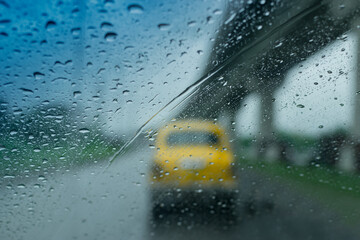 Raindrops falling on glass, abstract blurs - monsoon stock image of traditional yellow taxi of...