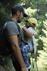 Father and his baby boy in a baby carrier