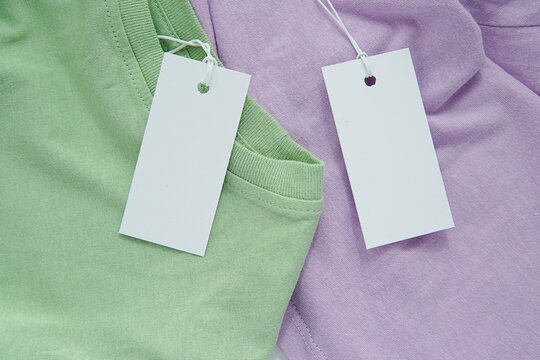 Summer sale concept, two white blank price tags on pastel colors summer clothes, tag mockup for logo, brand design or text.