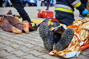 Rescuers provide first aid to the victim during a car accident. Person injured in the accident is...
