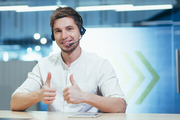 Portrait of male call center employee in modern office, businessman with call headset looking at...
