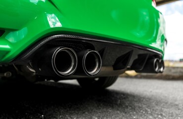 Green car with quad exhaust pipes viewed from below