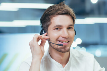 Close-up portrait of a man with a headset for a video call, looking at the camera and smiling...