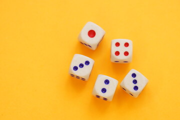 Five dice with different numbers on a orange sunny table