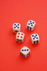 Five dice with different numbers on a red table