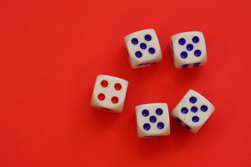 Dices with different numbers on a red table