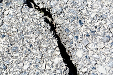 Cracked, broken and damaged asphalt road detail