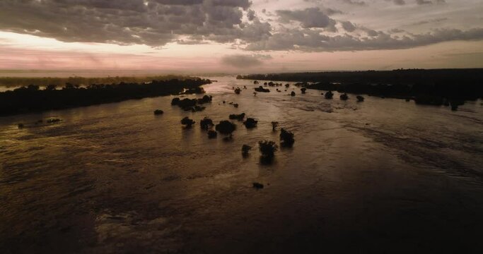 Aerial sunrise tilt-up view of the mist on the mighty Zambezi River flowing down to the Victoria Falls, Unesco world heritage site