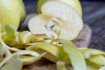 sliced and peeled green apple on a wooden board