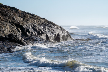 Beautiful beach with rough seas and strong waves crashing against the rocks
