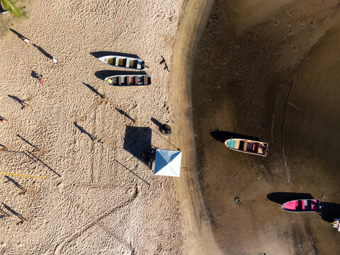 Top drone view of small fishing boats on river beach