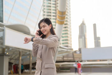 A young beautiful businesswoman is using Smart phone in Modern city , business technology , city lifestyle concept