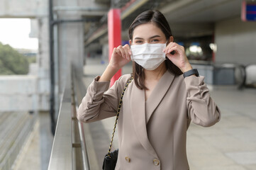 A portrait of  Businesswoman is wearing face mask work in modern City , people lifestyle , working under Covid-19 pandemic concept