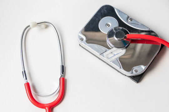 Red Stethoscope With Internal Hard Disk Drive Hdd Contains Health Record And Sensitive Patient Data With Hardware Doctor Checkup And Rest Before Data Loss On Faulty Storage System Or Encryption Breach