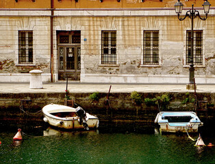 Fototapeta na wymiar Trieste, Italy - cityscape with the ancient Palazzo Carciotti and the Canal Grande, navigable canal in city center built in 18th century.