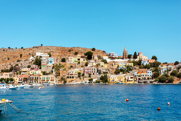 View on Greek sea Symi island harbor port, houses on island hills.