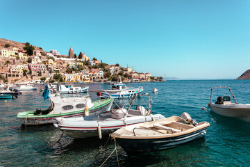 Obraz premium View on Greek sea Symi island harbor port, houses on island hills.