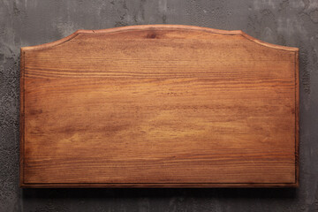 Wooden nameplate or sign board screwed at wall background. Front view of name plate
