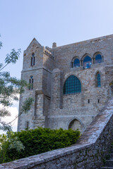 Fototapeta na wymiar Vue depuis les contrebas sur l'Abbaye du Mon Saint-Michel et son clocher surmonté de l'Archange Saint-Michel