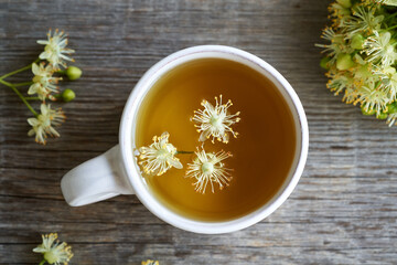 A ceramic cup of herbal tea with linden flowers, top view