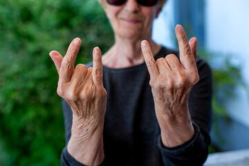 cool older hipster woman making gesture with her hands