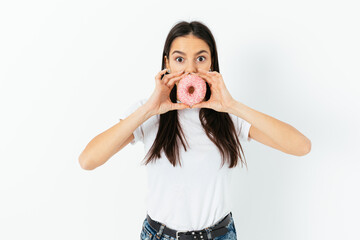 Surprised funny young woman holding donut like mouth