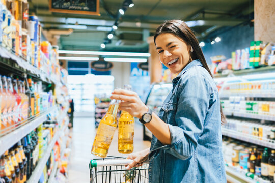 Portrait Joyful Young Woman Buying Beer In Liquor Store