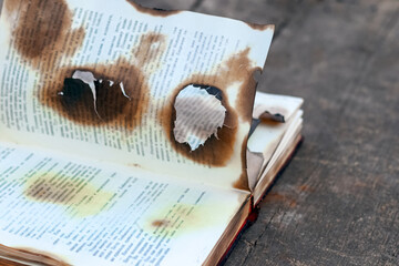 Burnt, charred book on a wooden table