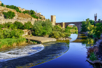 Fototapeta premium Tagus River as it passes through the medieval city of Toledo on a blue sky day.