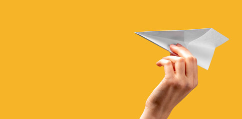 Banner with woman hand throwing origami plane on orange background. Freedom, start concept. Paper...