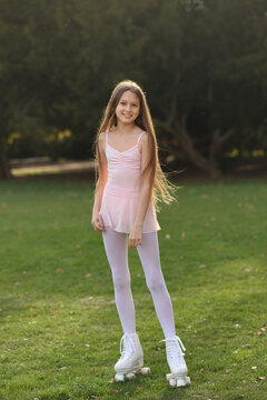 Beautiful girl with long hair in the park. Girl on roller skates. The girl smiles. Quad rollers.
