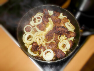 Gebratene Leber mit Zwiebelringe in der Pfanne