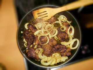 Gebratene Leber mit Zwiebelringe in der Pfanne