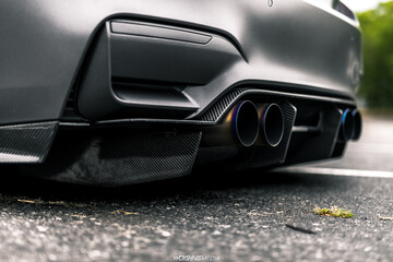 Obraz na płótnie Canvas Quad tip exhaust on a grey car