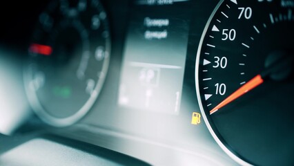 Car low fuel level indicator light, close-up shot