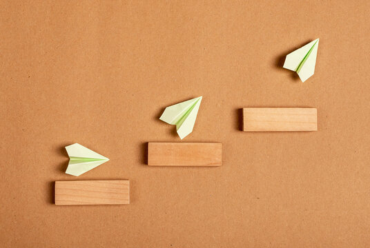 Progress, development concept. Origami planes flying up stairs. Professional, personal growth, success. High quality photo